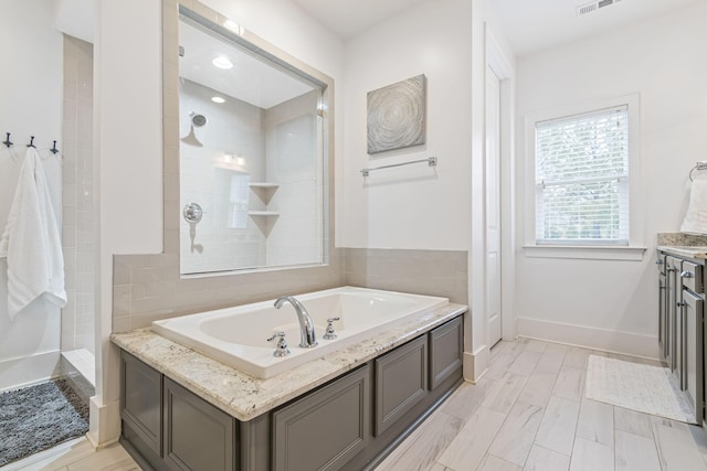 bathroom featuring visible vents, tiled shower, a garden tub, and baseboards