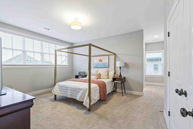 bedroom featuring visible vents, multiple windows, baseboards, and carpet