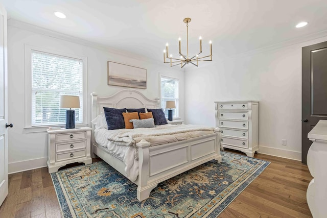 bedroom with baseboards, a notable chandelier, wood finished floors, and crown molding