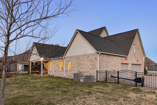 view of side of home with central air condition unit, a yard, fence, and a garage