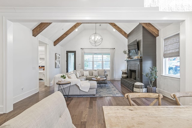 living room featuring wood finished floors, baseboards, a fireplace, beamed ceiling, and a chandelier