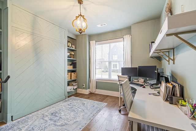 office space featuring visible vents, an inviting chandelier, baseboards, and dark wood-style flooring