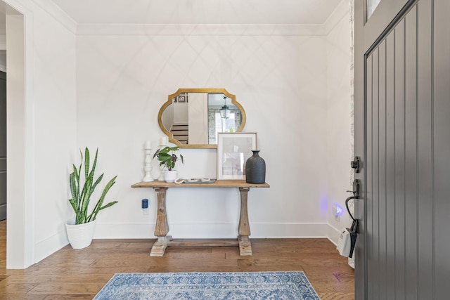 entryway featuring crown molding, baseboards, and wood finished floors