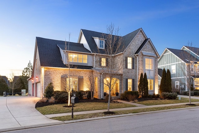 view of front of home featuring brick siding, roof with shingles, and concrete driveway