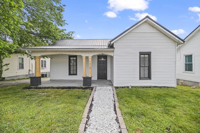 view of front of home with a porch, a front yard, and metal roof