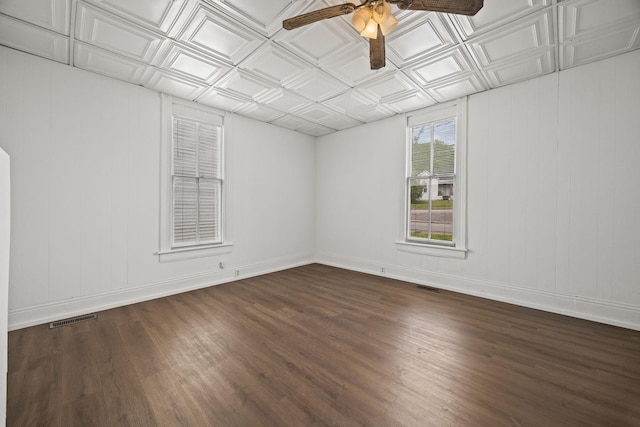 spare room with ceiling fan, dark wood finished floors, an ornate ceiling, and visible vents