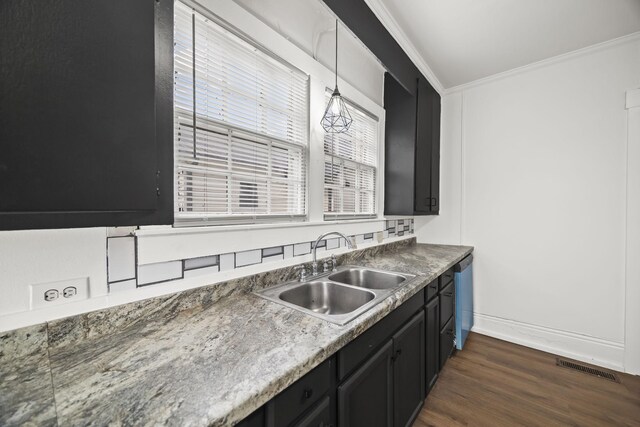 kitchen with a sink, dark cabinets, dishwasher, ornamental molding, and visible vents