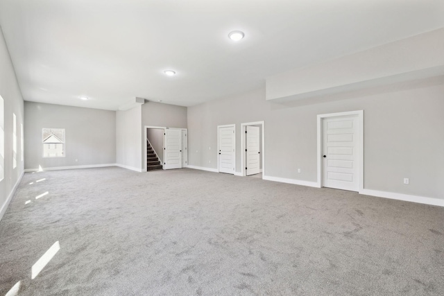 empty room with baseboards, carpet floors, and stairs