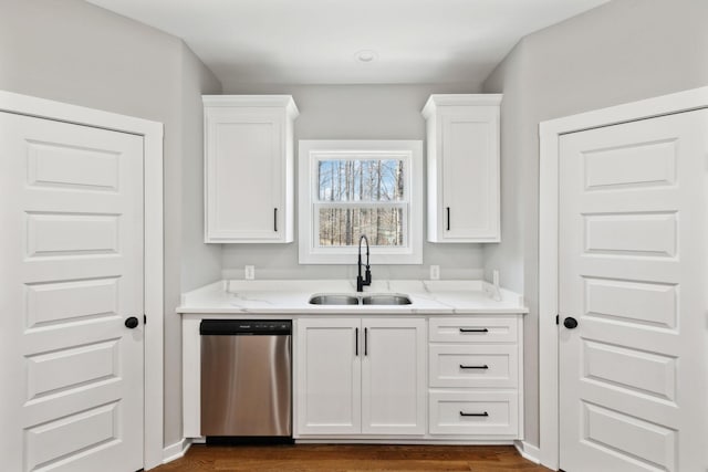 kitchen with a sink, light stone countertops, stainless steel dishwasher, and white cabinetry