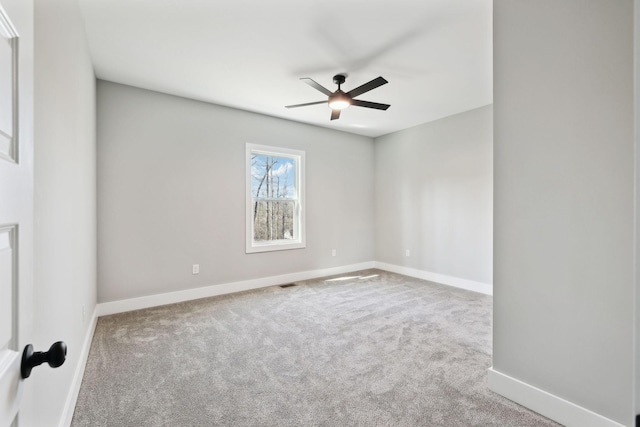 carpeted spare room with baseboards and ceiling fan