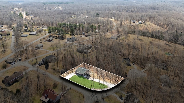 birds eye view of property featuring a forest view