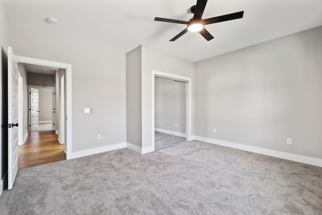 unfurnished bedroom featuring a closet, a ceiling fan, baseboards, and carpet floors