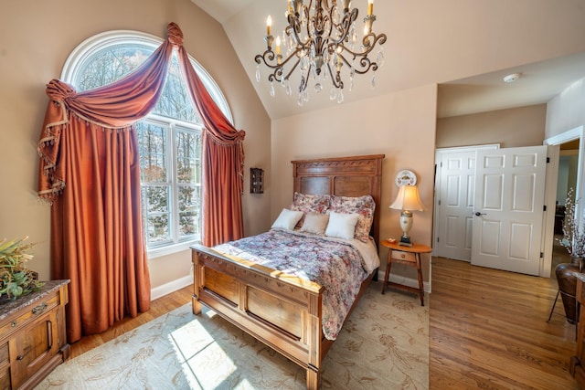 bedroom featuring baseboards, lofted ceiling, and light wood-style floors