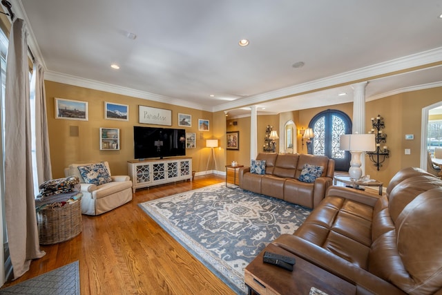 living area with recessed lighting, wood finished floors, crown molding, and decorative columns