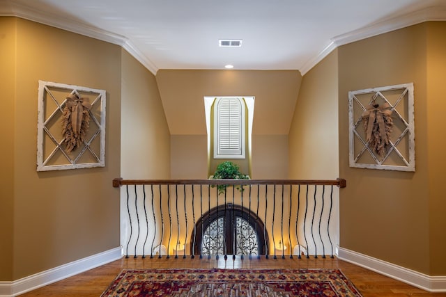 stairway featuring wood finished floors, crown molding, baseboards, and visible vents