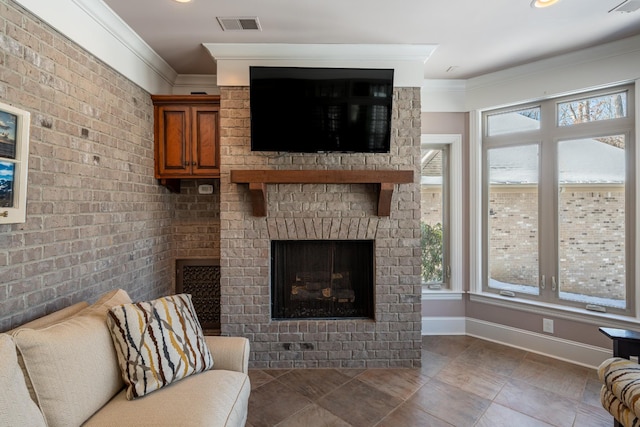 living area with baseboards, visible vents, brick wall, a fireplace, and ornamental molding