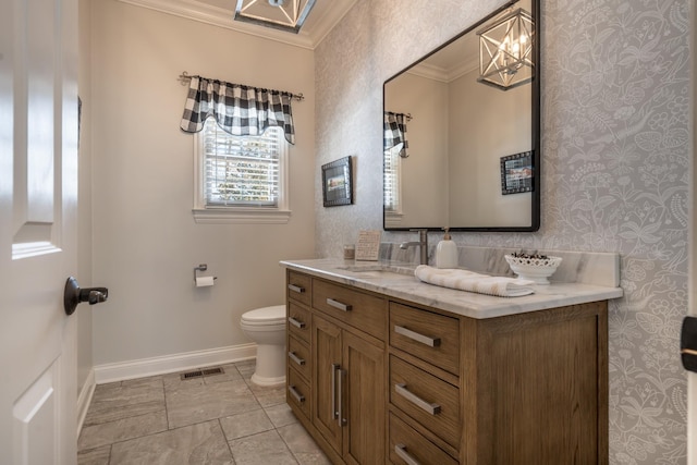 bathroom with vanity, baseboards, wallpapered walls, crown molding, and toilet