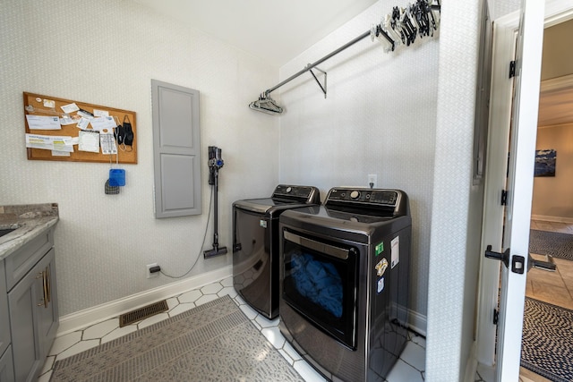 washroom featuring washer and dryer, cabinet space, baseboards, and visible vents