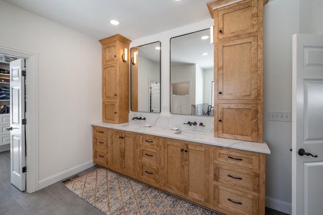 bathroom featuring double vanity, recessed lighting, and a sink