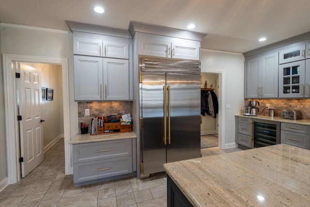 kitchen with wine cooler, gray cabinetry, light stone countertops, and stainless steel built in refrigerator