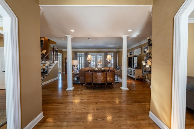 living area featuring stairs, ornate columns, and wood finished floors