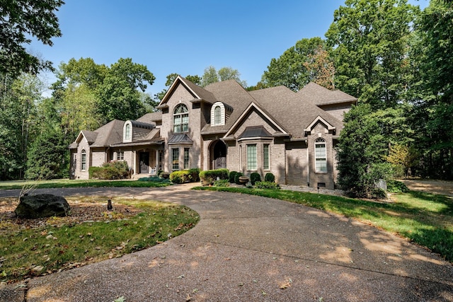 french provincial home with brick siding, crawl space, concrete driveway, and roof with shingles