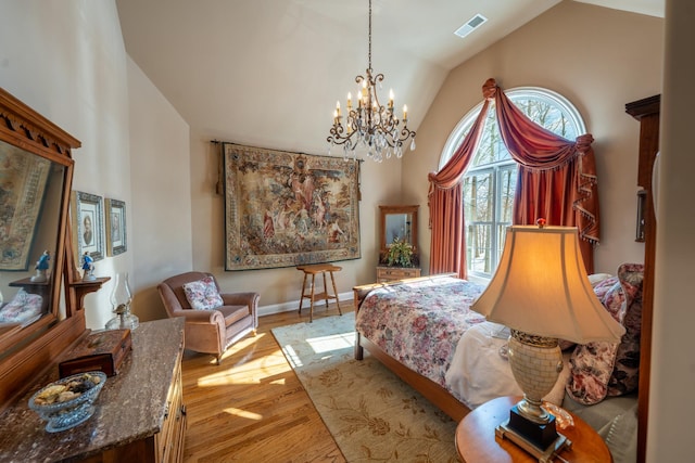 bedroom with visible vents, high vaulted ceiling, baseboards, and wood finished floors