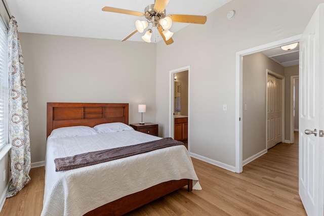 bedroom featuring baseboards, light wood-type flooring, ensuite bathroom, and ceiling fan