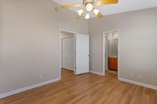 unfurnished bedroom with ensuite bathroom, light wood-style floors, baseboards, and a closet