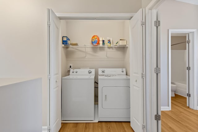 laundry room featuring laundry area, light wood finished floors, and washer and clothes dryer