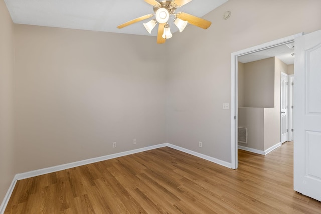 spare room with visible vents, light wood-style flooring, a ceiling fan, and baseboards