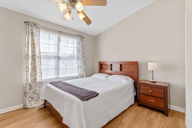 bedroom with baseboards, light wood-style floors, ceiling fan, and vaulted ceiling