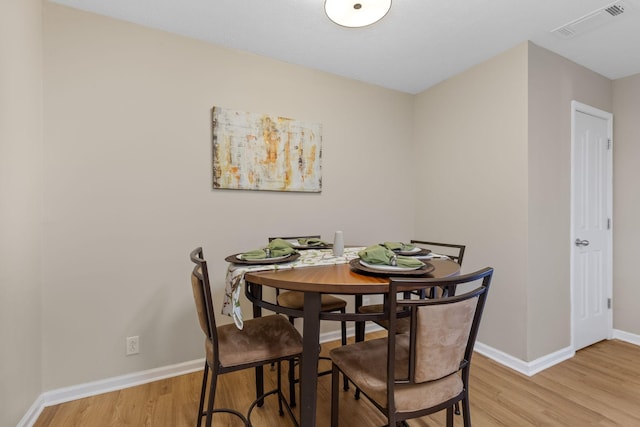 dining area with visible vents, light wood-style flooring, and baseboards