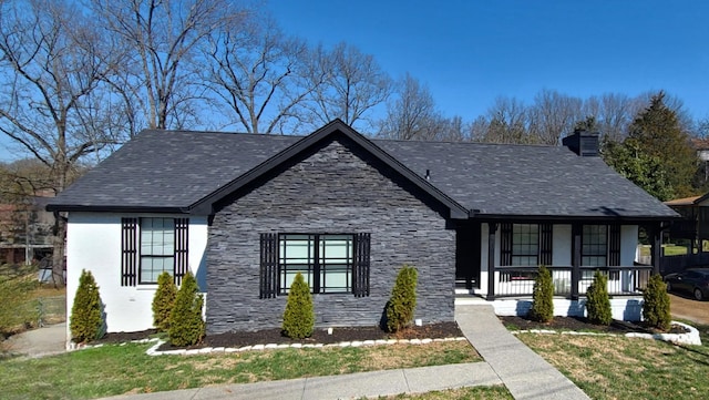 view of front of home featuring roof with shingles, a porch, stucco siding, a chimney, and stone siding