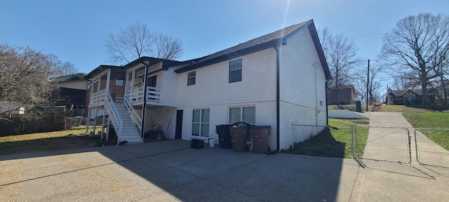 exterior space featuring stairway, brick siding, and fence