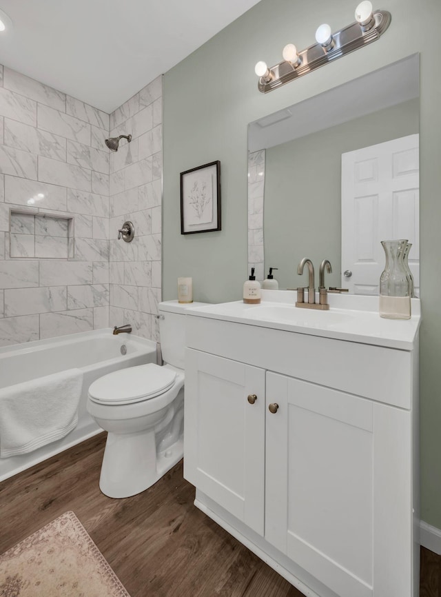 full bathroom featuring vanity, washtub / shower combination, toilet, and wood finished floors