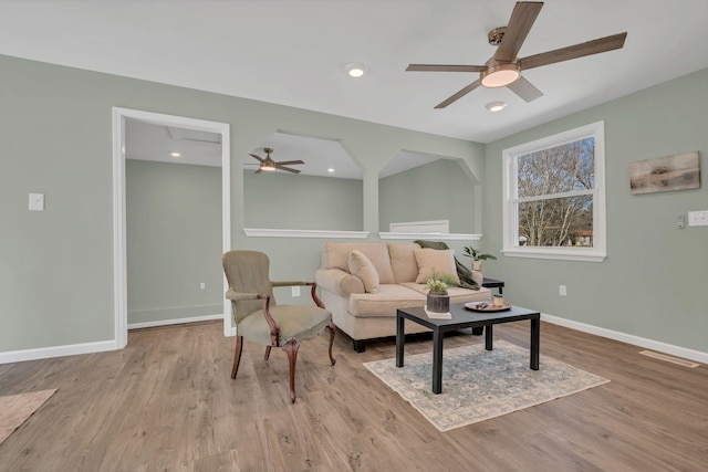 living area featuring recessed lighting, baseboards, and wood finished floors