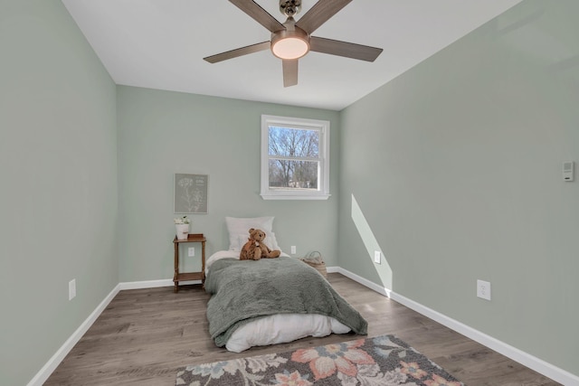 bedroom featuring ceiling fan, baseboards, and wood finished floors