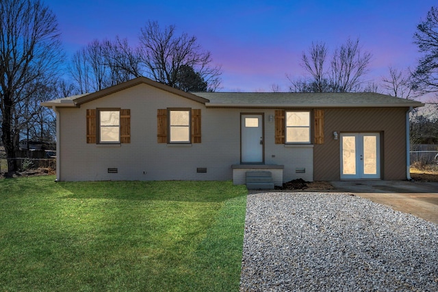 view of front of home with crawl space, brick siding, a front yard, and fence