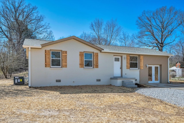 view of front of house with crawl space, brick siding, french doors, and a shingled roof