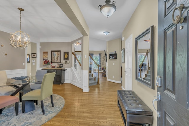 dining space with stairs, light wood-style flooring, radiator, and wainscoting