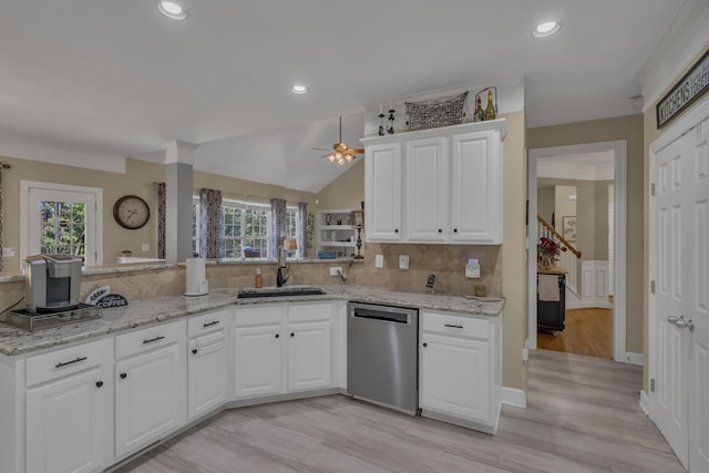 kitchen featuring a sink, tasteful backsplash, stainless steel dishwasher, a peninsula, and white cabinets