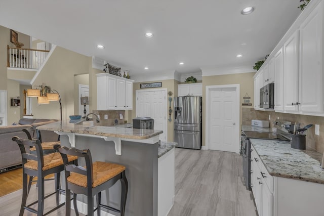 kitchen featuring stainless steel appliances, a peninsula, open floor plan, and decorative backsplash