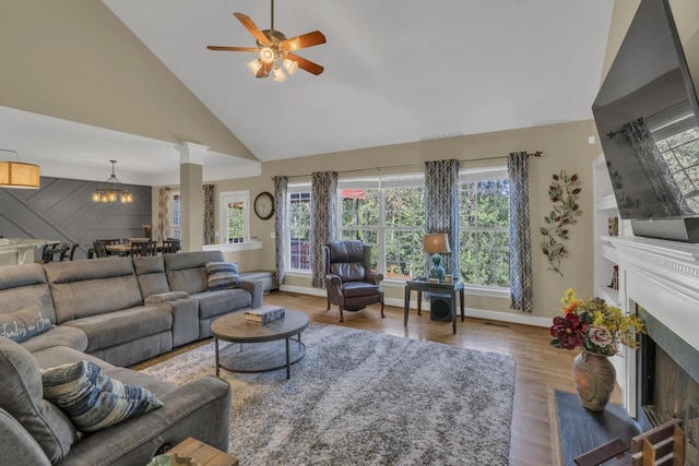 living room featuring decorative columns, a fireplace, wood finished floors, high vaulted ceiling, and a ceiling fan