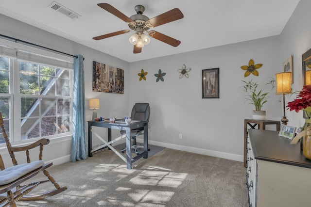 office space featuring carpet flooring, baseboards, visible vents, and ceiling fan