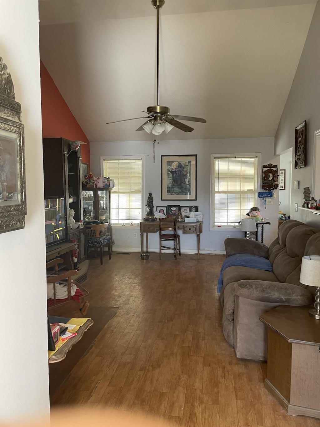 living room with a wealth of natural light, high vaulted ceiling, wood finished floors, and a ceiling fan