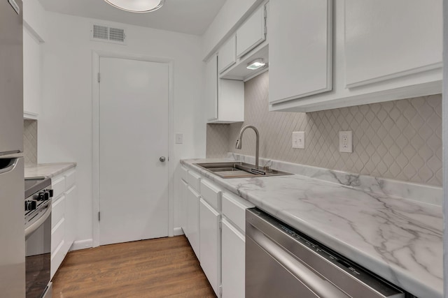 kitchen featuring visible vents, a sink, backsplash, stainless steel appliances, and white cabinets