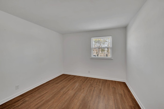 empty room featuring baseboards and wood finished floors