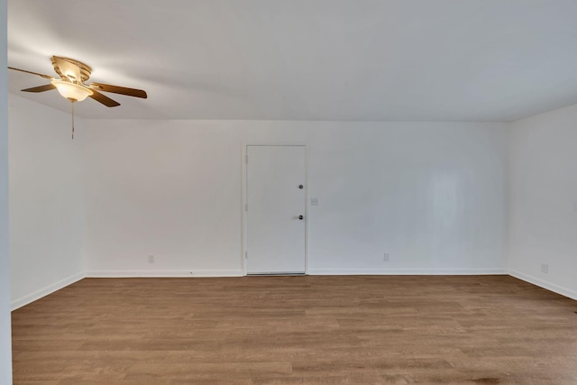 unfurnished room featuring ceiling fan, baseboards, and wood finished floors