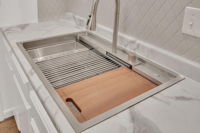 interior details featuring a sink and light stone counters